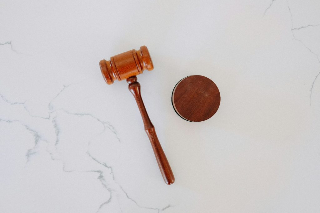 Wooden gavel and block on white desk.