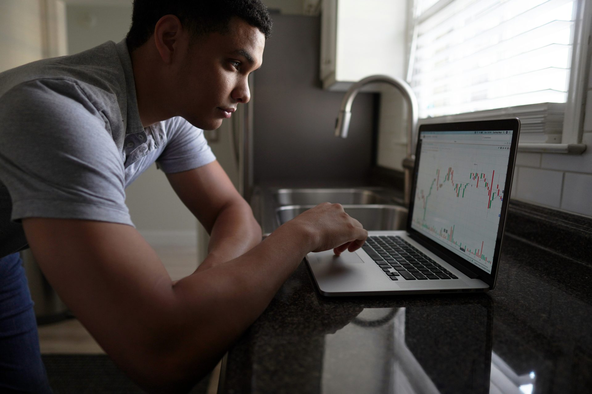 Man checking stock charts on laptop.