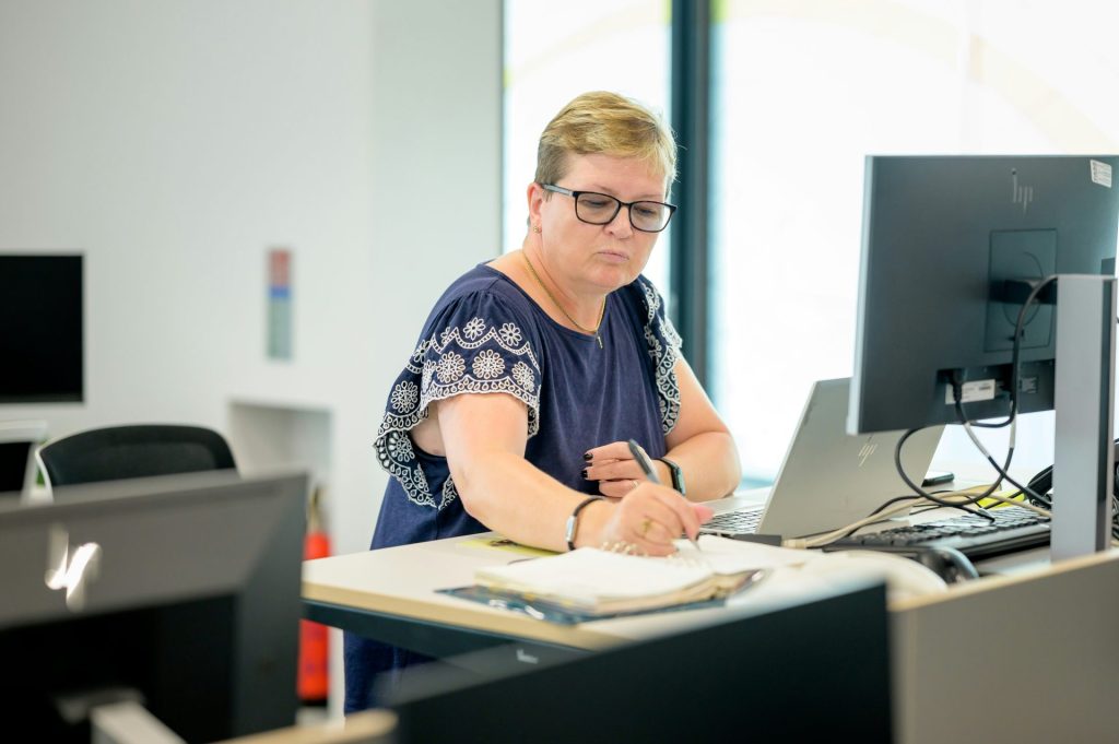 Woman writing notes while working at desk